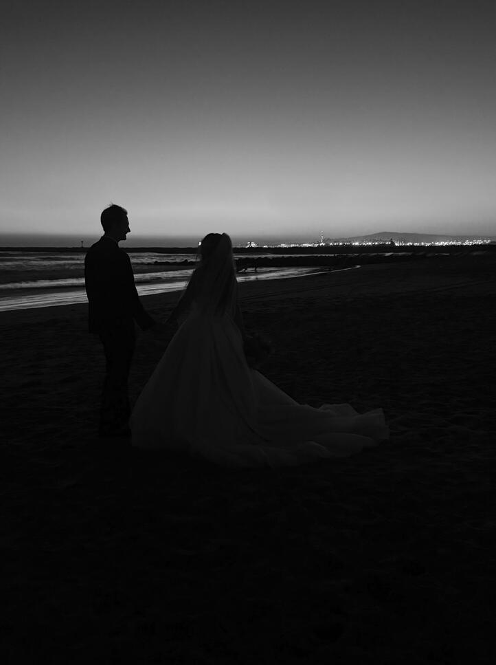 Erin &amp; Paul holding hands at night on the beach.